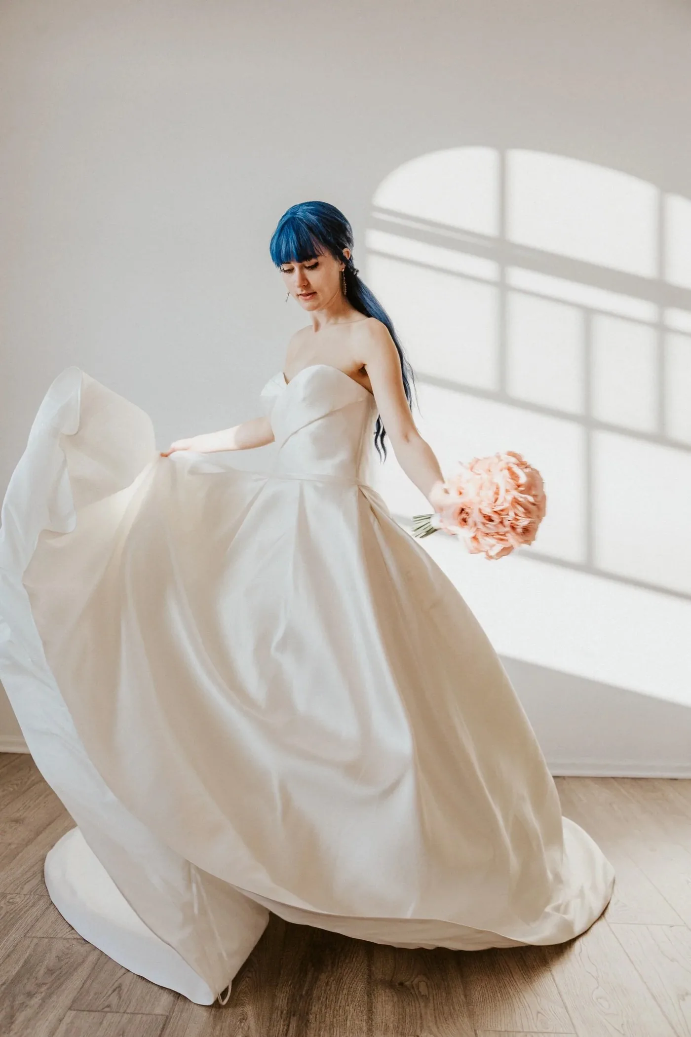 Bride in a structured satin wedding gown holding flowers