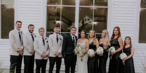 Wedding feature of the Springs Wallisville couple: Halie and Jacob, posing together in the grass behind the wedding venue.