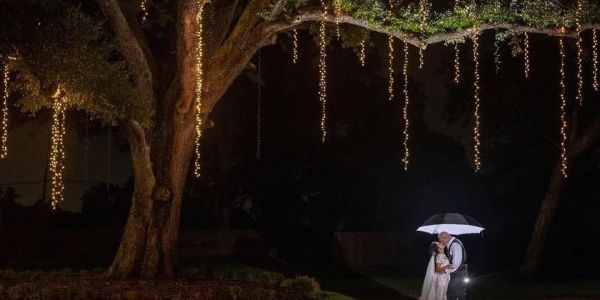 Bella Moon Barn Event Venue with giant oak tree and lights with couple under the dark sky